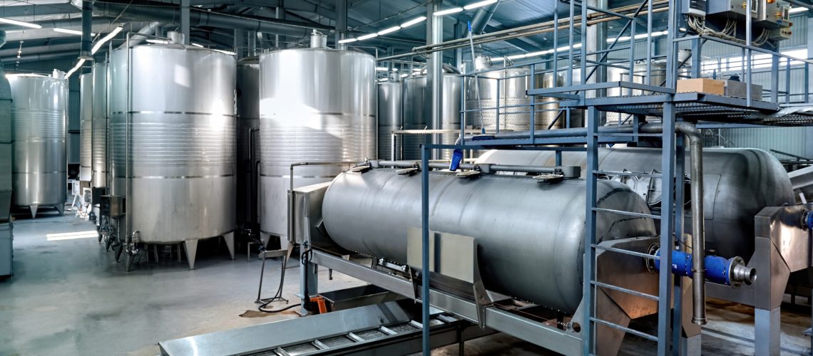 Metal wine storage tanks in a winery. Wide shot